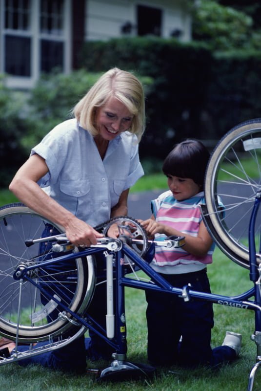 bilde; voksen dame og barn reparer sykkel